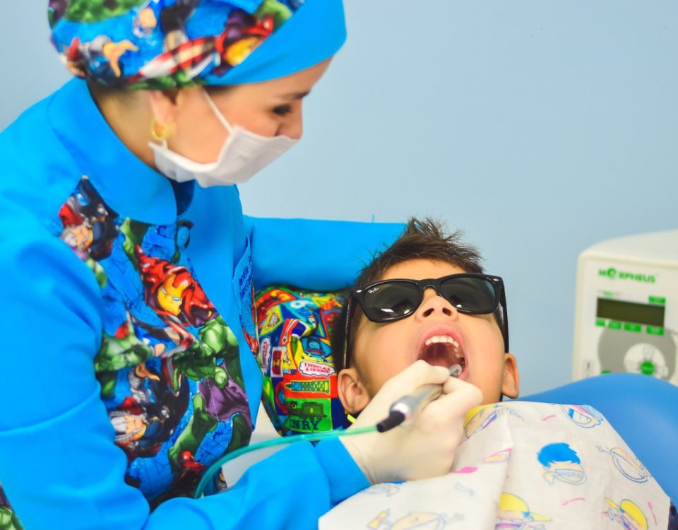 Pediatric dentist examining a young boy's teeth